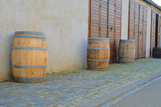 Old rustic wine barrels in front of modern wine cellar. Wine background in Europe. Czech Republic, South Moravia. 