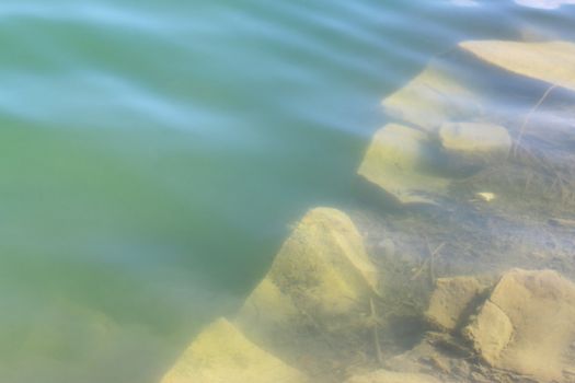Large basalt rock under water. Beautiful geological lake
