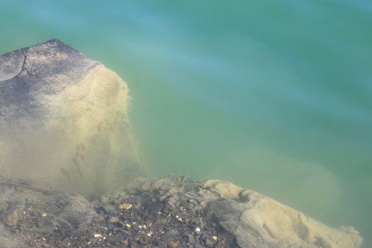 Basalt rock under water. Beautiful geological lake