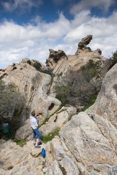 Palau,Italy,09-Apr-2018:Adult woman at the big rocks and beautifull nature of the capo dorso in sardinia italy, capo dorso or the bear rock is a landmark wth beautifull rocks at the costa emeralda