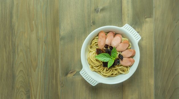 Spaghetti with sausage  and dried peppers , hot and spicy on wooden background, top view