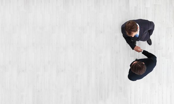 Business men shaking hands, finishing up a meeting, top view with copy space