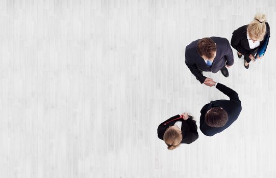 Business people shaking hands, finishing up a meeting, top view with copy space