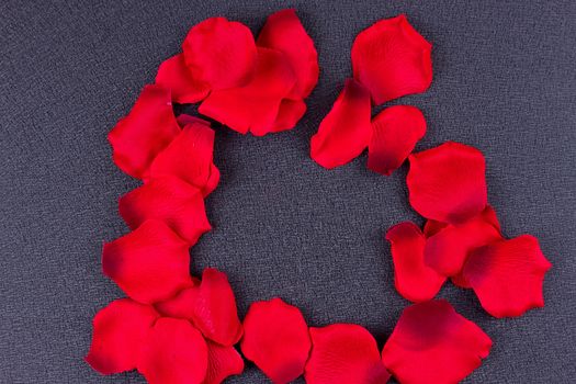 Artificial petals red roses black background frame