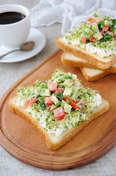 Sandwich for breakfast from tender, juicy germinated alfalfa sprouts with soft ricotta, tomato and avocado slices, with a cup of coffee or tea, which may be better for a break