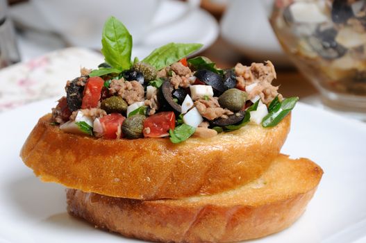 Fried toast with chopped tuna with egg, cubes of tomatoes and olive slices, capers