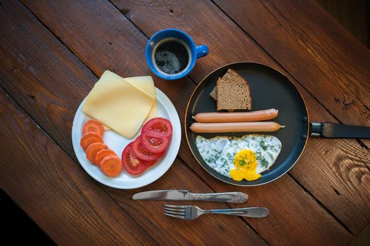 Delicious breakfast with scrambled eggs, sausages, carrots, cheese, bread and coffee. Food and health.