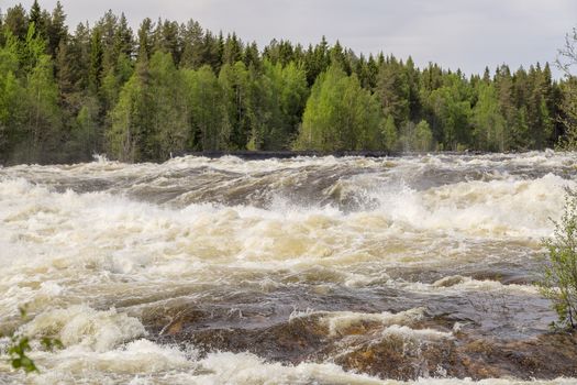 The rapids at Renforsen in Vindeln, Sweden with a partly cloudy sky.