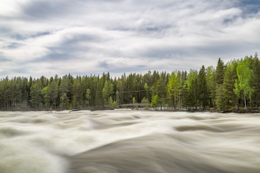 The rapids at Renforsen in Vindeln, Sweden with a partly cloudy sky.