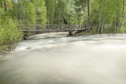 The rapids at Renforsen in Vindeln, Sweden with a wooden bridge.