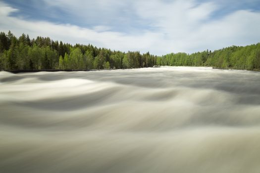 The rapids at Renforsen in Vindeln, Sweden with a partly cloudy sky.