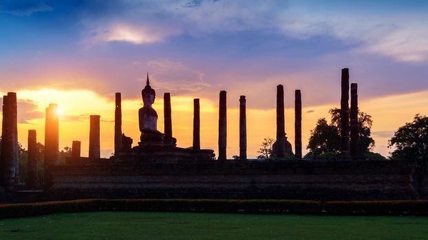 Silhouette of Buddha statue and Wat Mahathat Temple in the precinct of Sukhothai Historical Park, Wat Mahathat Temple is UNESCO World Heritage Site, Thailand.