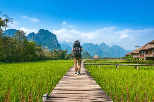 Tourism with backpack walking on wooden path, Vang vieng in Laos.