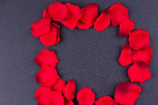 Artificial petals red roses black background frame