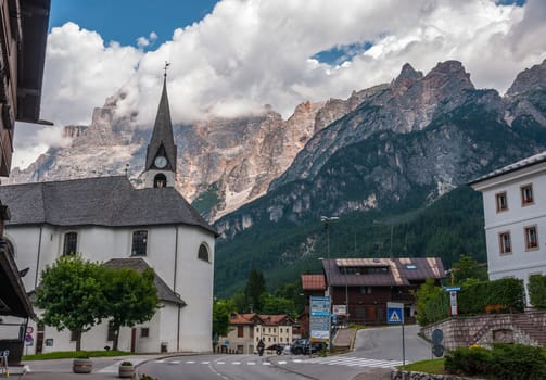 Summer view of Dolomites of Cortina d'Ampezzo (BL) (Italy). Mountains, clouds, sky and church.
