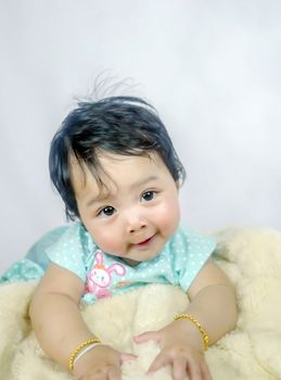 Asian Smiling baby girl crawling in bedroom