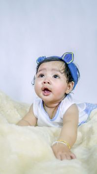 Asian Smiling baby girl crawling in bedroom