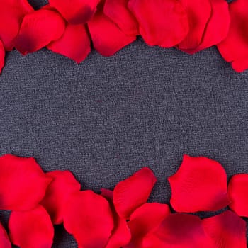 Artificial petals red roses black background frame