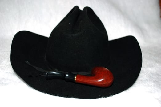 Felt black hat with a pipe on a white background