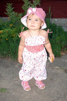 standing girl in a bright dress and a hat on a background of green