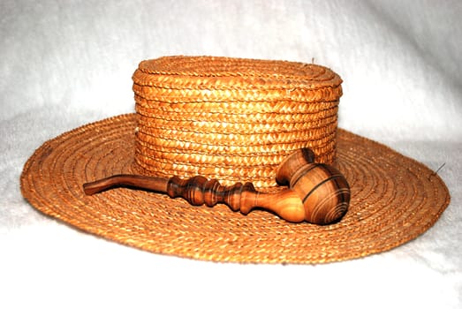 straw hat with a wooden smoking pipe on a white background