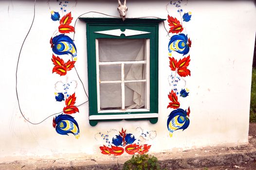 facade of the Ukrainian hut with a painting around the window
