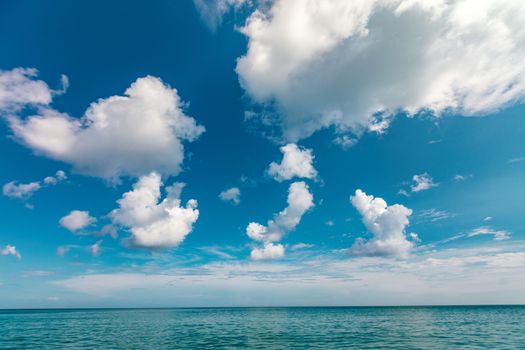 summer season beautiful blue calm sea and deep blue sky with fluffy clouds