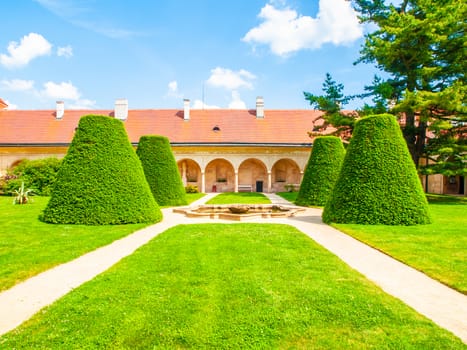 Renaissance internal chateau garden with trim lawn and trees on sunny summer day. Telc, Czech Republic. UNESCO World Heritage Site.