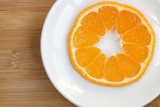 Cross thin cut of tangerine on a plate