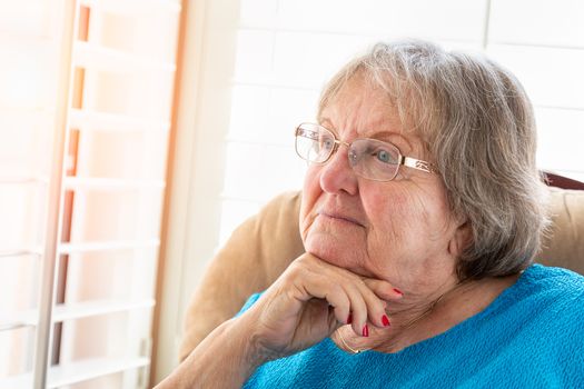 Contemplative Senior Woman Gazing Out of Her Window.