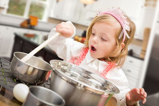 Cute Baby Girl Playing Cook With Pots and Pans In Kitchen.