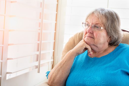 Contemplative Senior Woman Gazing Out of Her Window.