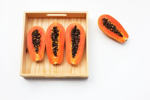 Papaya in wooden box on white background. Copy space