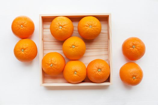 Fresh orange citrus fruit in wooden box isolated on white background.  Top view