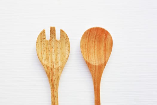 Wooden spoon and fork on white background.