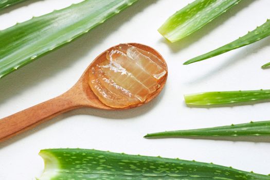 Aloe vera fresh leaves with aloe vera gel on wooden spoon. isolated on white