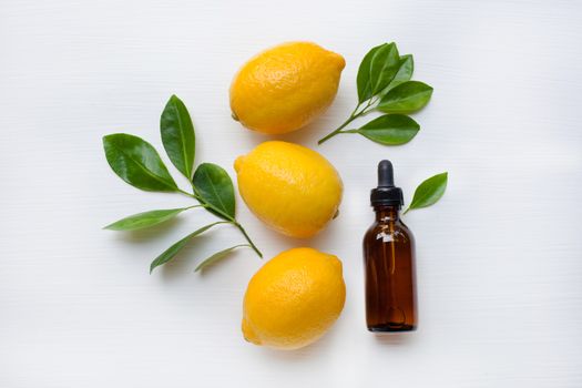 Fresh lemon with lemon essential oil on a white background.