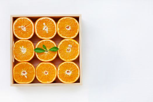 Fresh orange citrus fruit in wooden box isolated on white background.  Top view