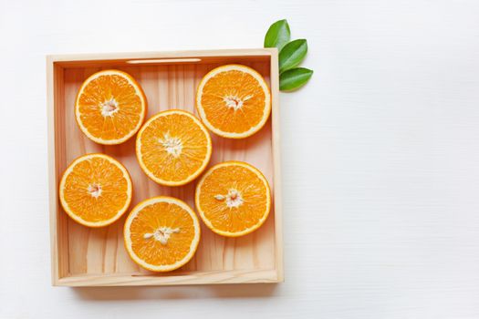 Fresh orange citrus fruit in wooden box isolated on white background.  Top view