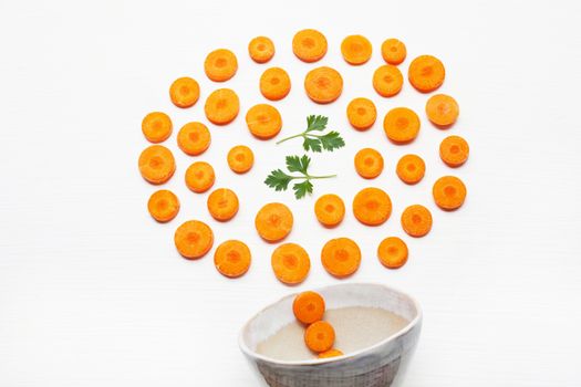 Chopped carrot slices  and parsley leaves with bowl  isolated on white background.