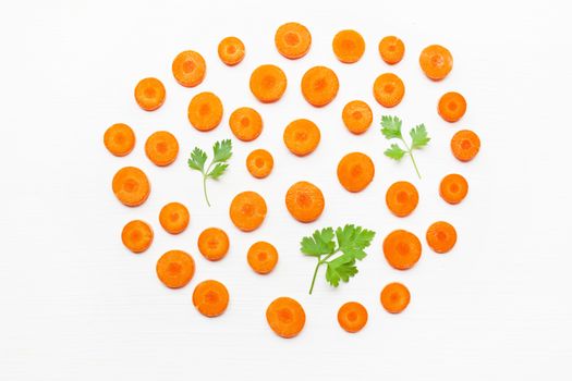 Chopped carrot slices and parsley leaves  isolated on white background.