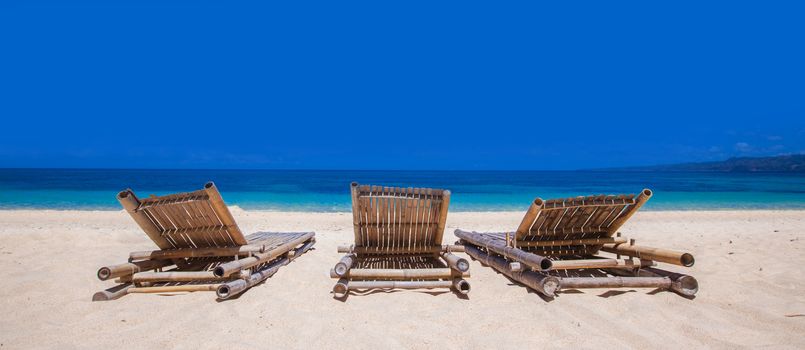 Relaxing couch chairs on white sandy beach at Philippines