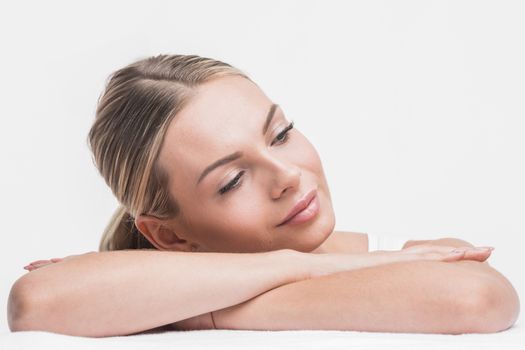 Beautiful sensual woman holding head on stacked hands. Beauty and skincare concept. Isolated over white.