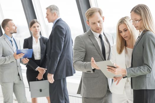 Confident business team talking in office against the window