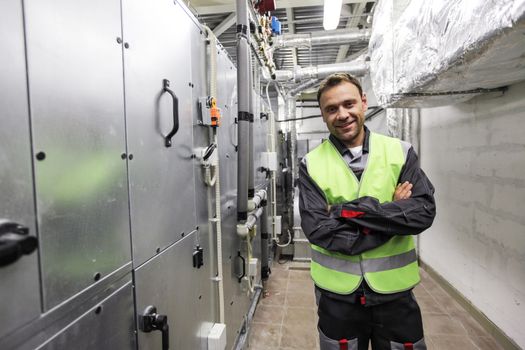 Portrait of smiling worker in electrical switchgear room of CNC plant