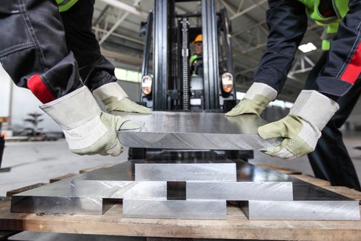 Workers taking aluminium billet at CNC machine shop