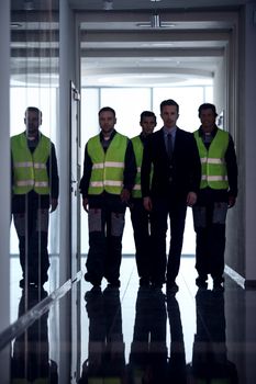 Business people and workers moving along the corridor at factory