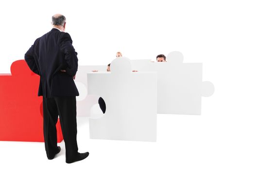 Angry businessman threatens colleague responsible for laziness, staff afraid hiding behind puzzle