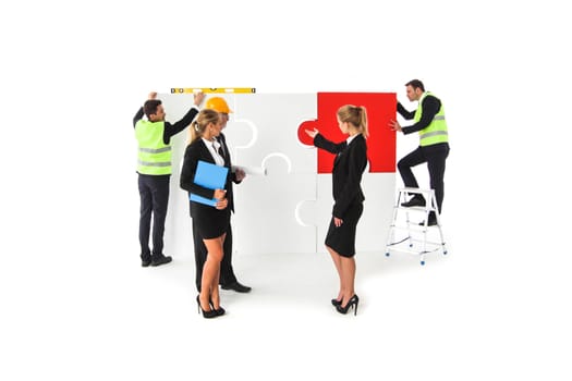 Team of business people and workers assmebling puzzle isolated on white