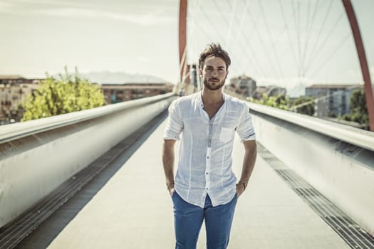 One handsome young man in urban setting in European city, standing